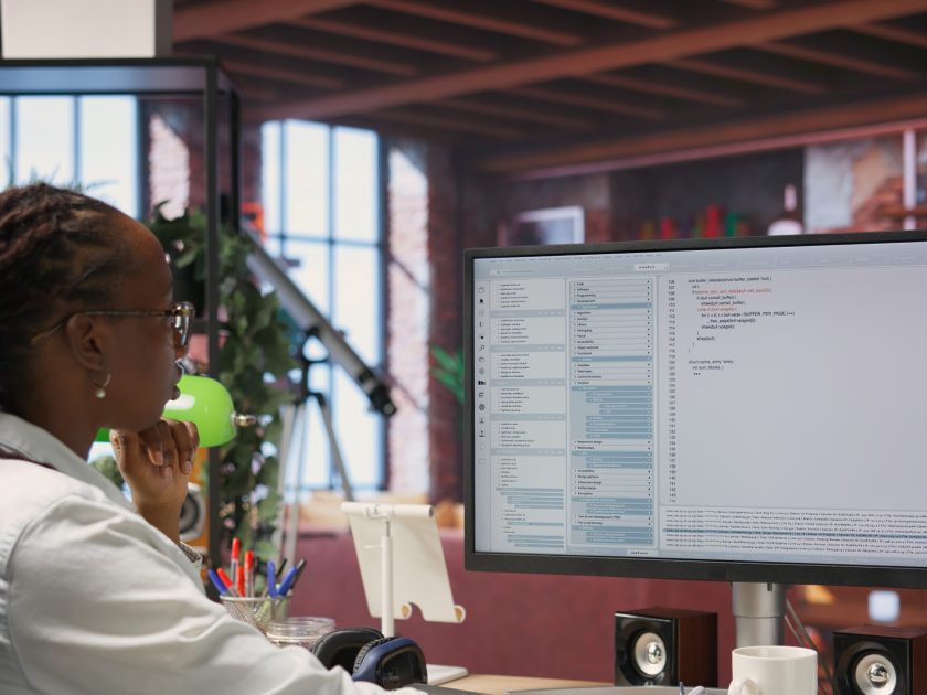 System administrator types code into PC, developing software, entering commands. IT professional at home fixing errors in application, implementing new features, listening music, camera B